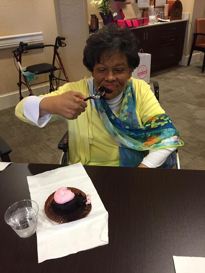 A woman enjoying a piece of cake indoors.