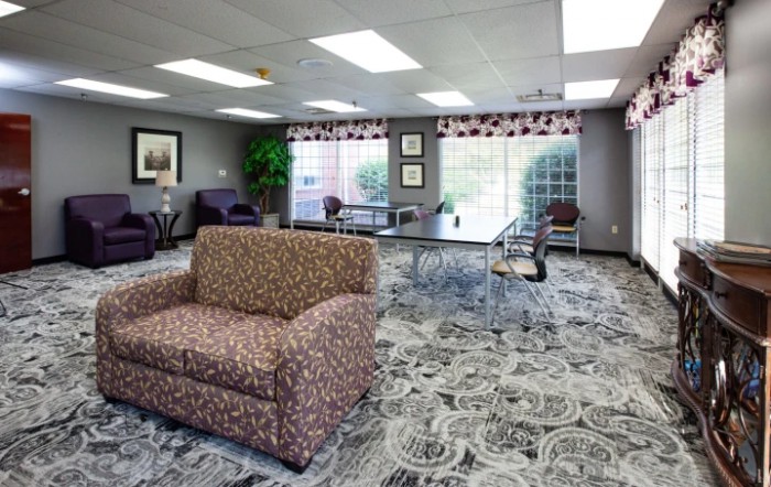 A spacious lobby area with comfortable seating and large windows providing natural light.