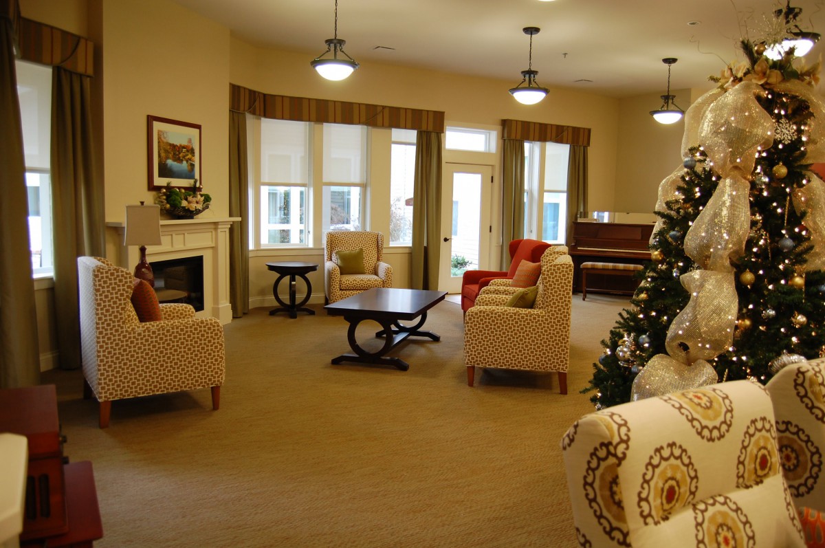 A cozy living room with a fireplace, comfortable seating, and festive decorations.