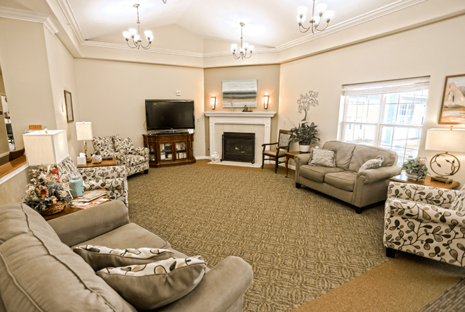 A cozy living room with sofas arranged around a fireplace and television.