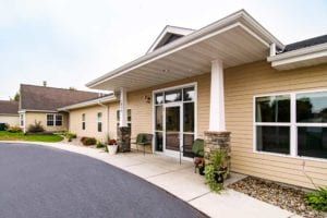 A modern building entrance with a paved walkway and columns.