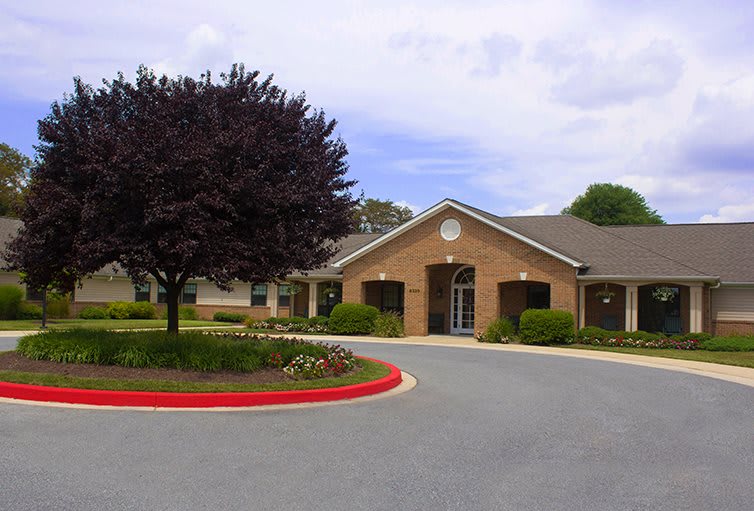 A suburban brick building with a landscaped entrance and driveway.