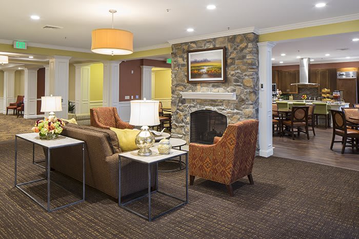 A cozy living room with comfortable seating and a stone fireplace.