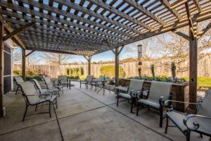 A spacious patio with a pergola and comfortable outdoor seating.