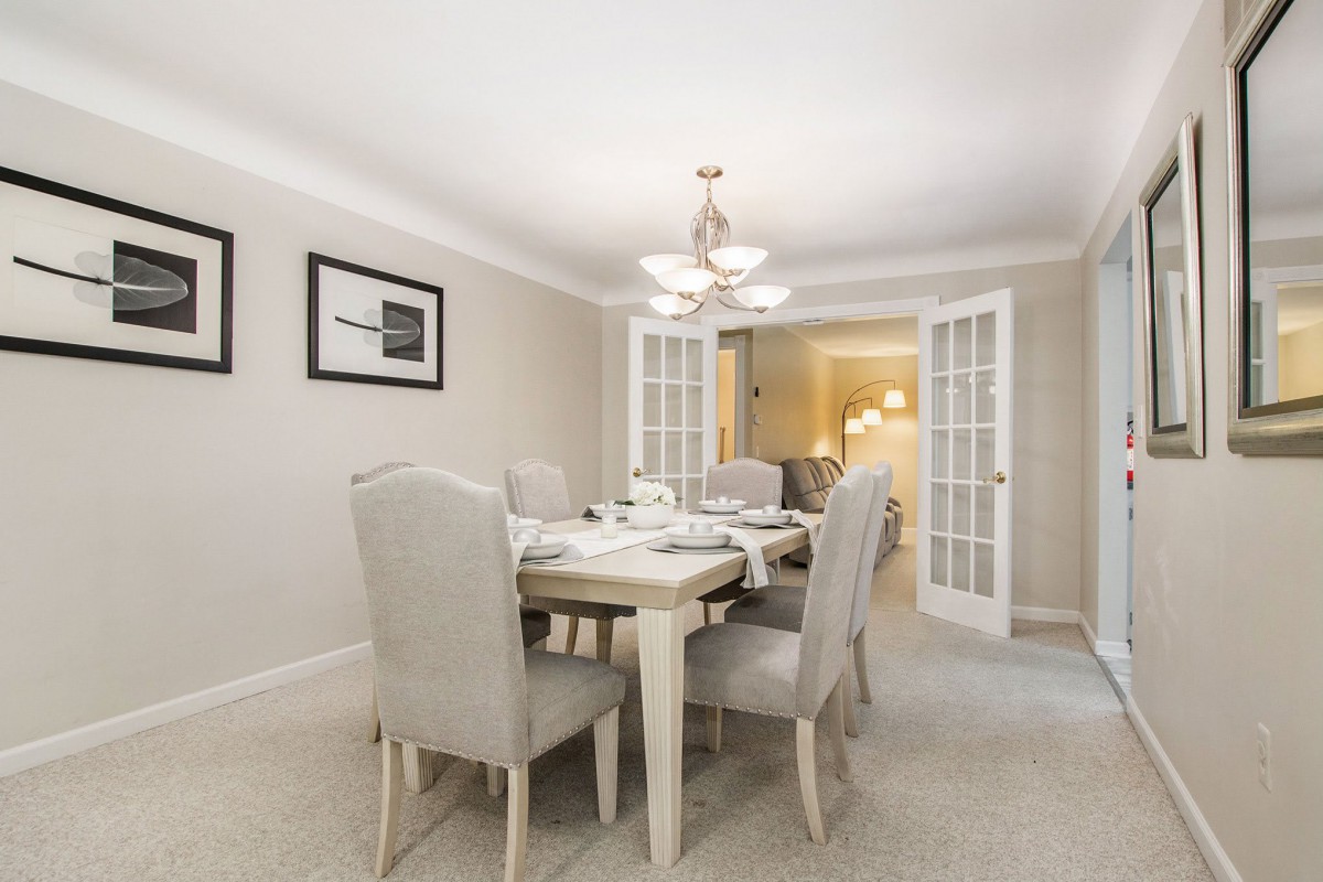 A modern dining room with a set table and elegant decor.