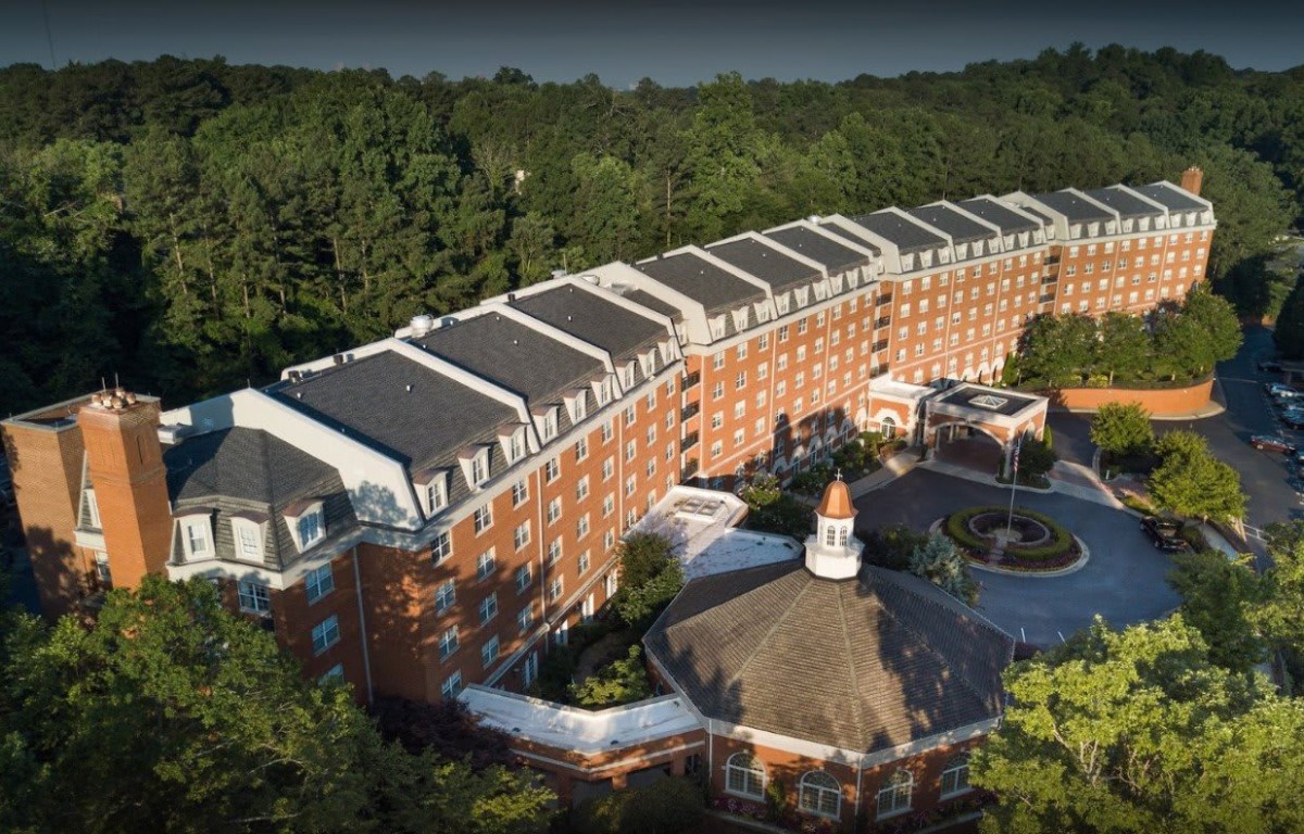 Aerial view of a large brick building surrounded by trees.