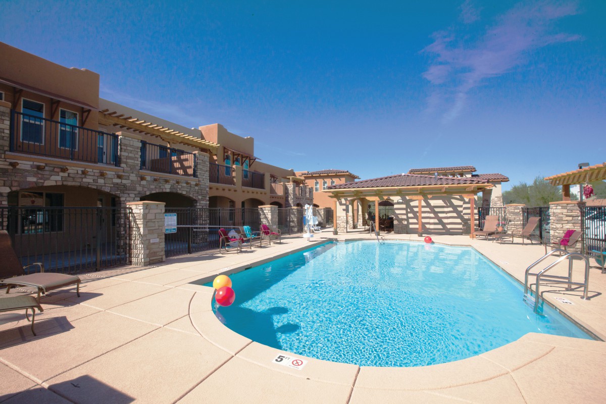 A sunny day at a luxurious resort with a sparkling outdoor pool.