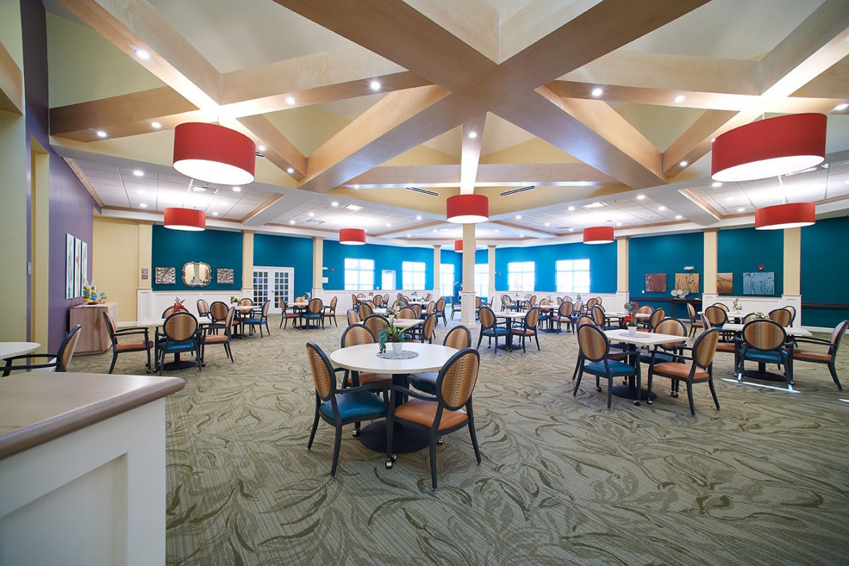 A spacious dining area with modern decor, featuring tables, chairs, and stylish lighting fixtures.
