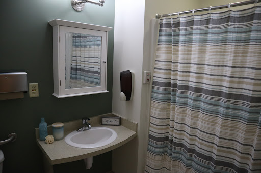 A cozy and neatly arranged bathroom featuring a sink, mirror, and a striped shower curtain.