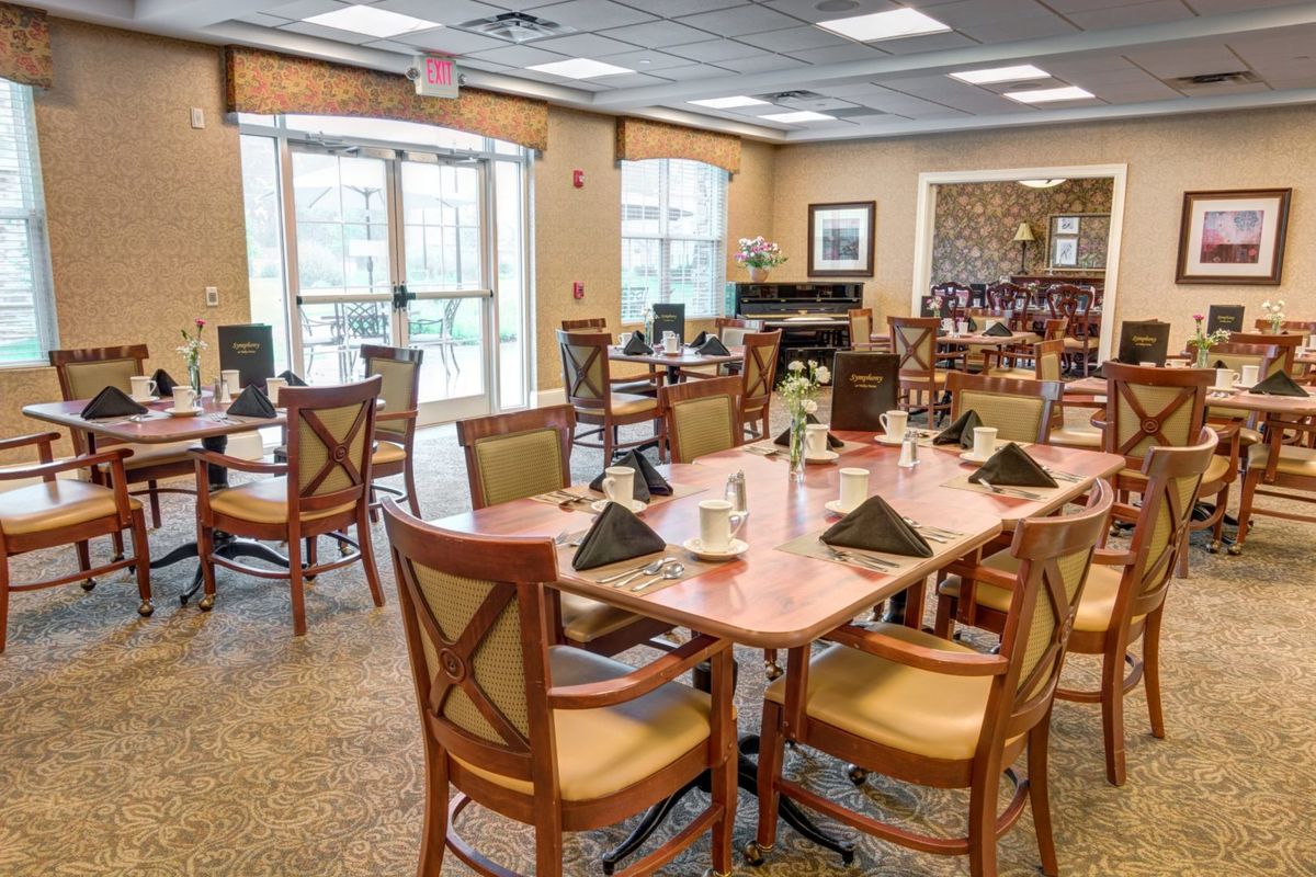 A well-lit dining area with neatly arranged tables and chairs, featuring elegant interior decor.