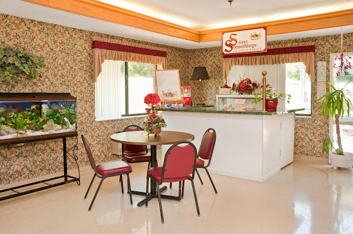 A cozy cafe setting featuring a small table and chairs with floral decor.