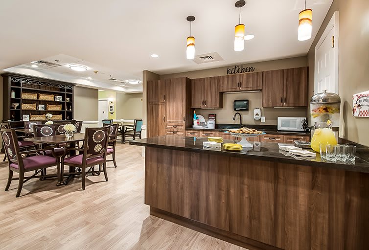 A modern kitchen and dining area featuring wood cabinetry and contemporary lighting.