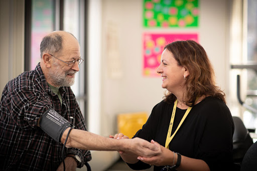 A joyful interaction between a healthcare professional and an elderly patient during a routine check-up.