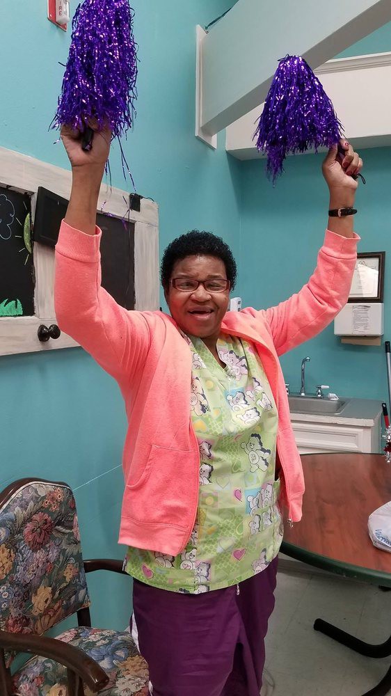 A person joyfully raises their arms in celebration indoors.
