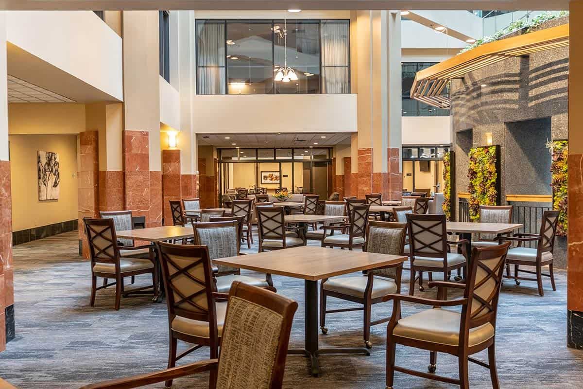 An indoor seating area with multiple tables and chairs arranged in a spacious layout.