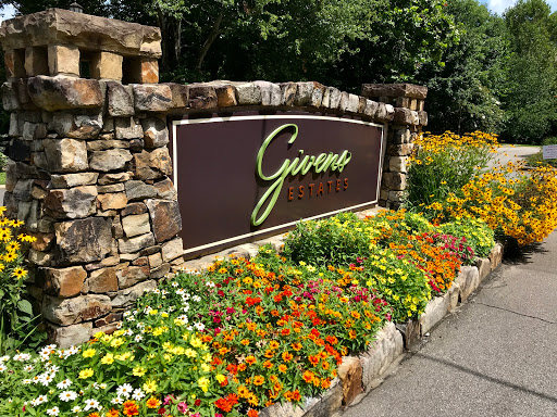 A beautifully landscaped entrance sign adorned with colorful flowers.
