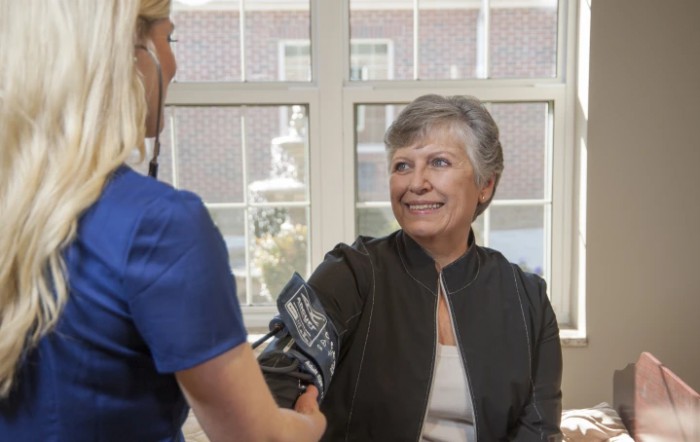 A healthcare professional checks a patient's blood pressure during a medical consultation.
