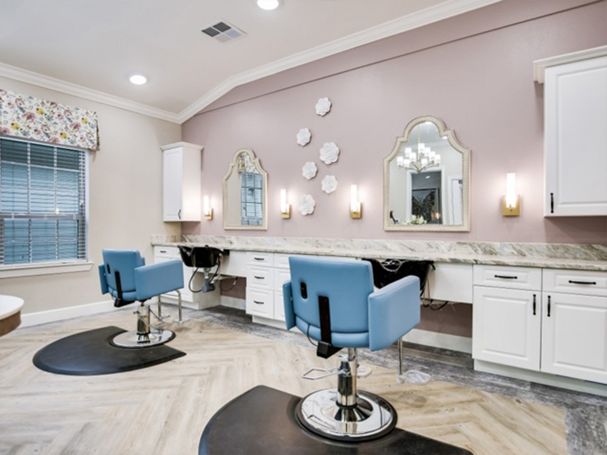 A stylish beauty salon interior with blue chairs, decorative mirrors, and soft lighting.