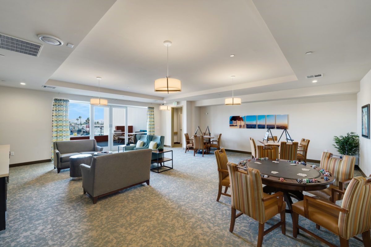 A spacious and modern living room with a dining area, featuring comfortable seating and elegant lighting.