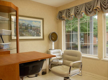 A cozy office space with a desk, chair, and large window.