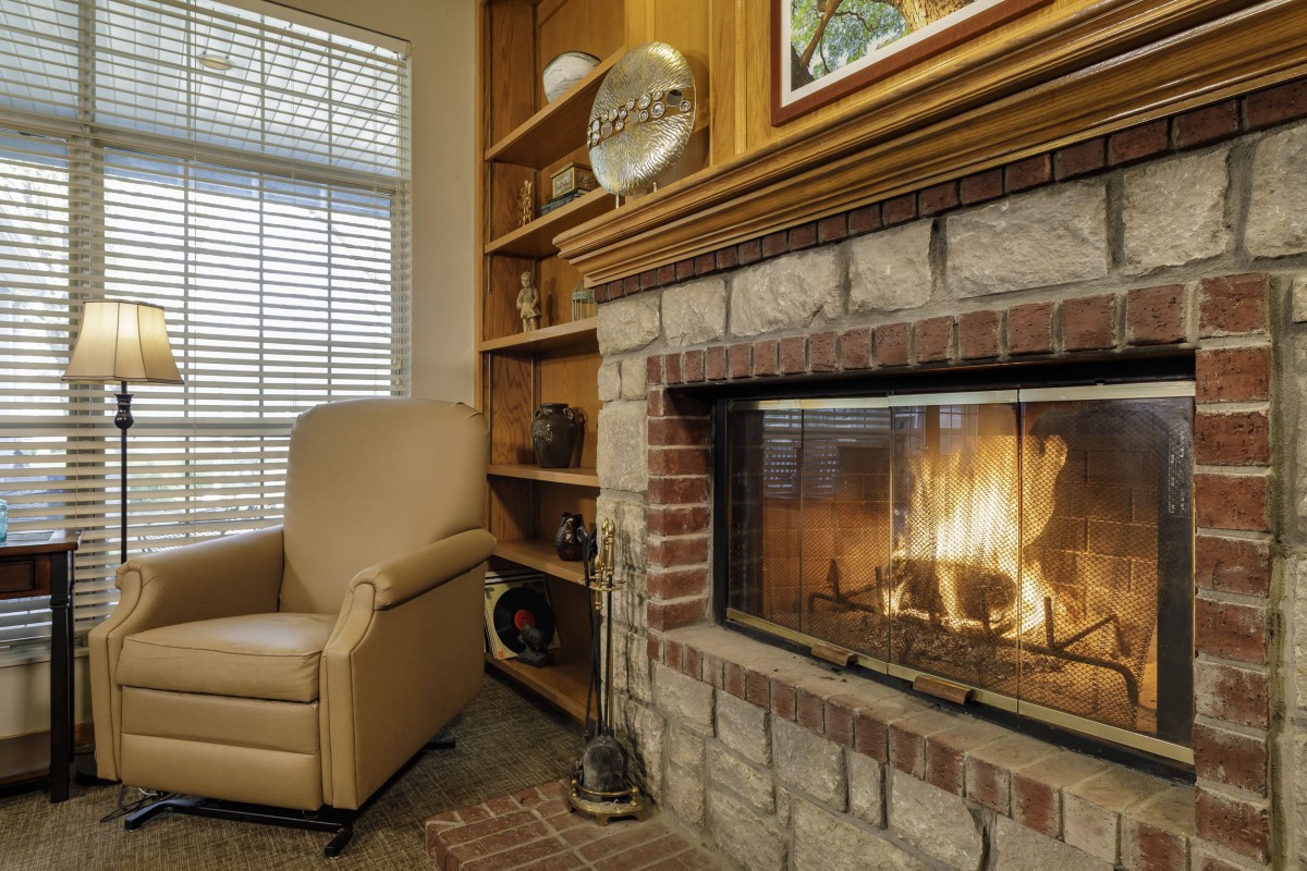 A cozy living room with a warm fireplace and a comfortable chair.