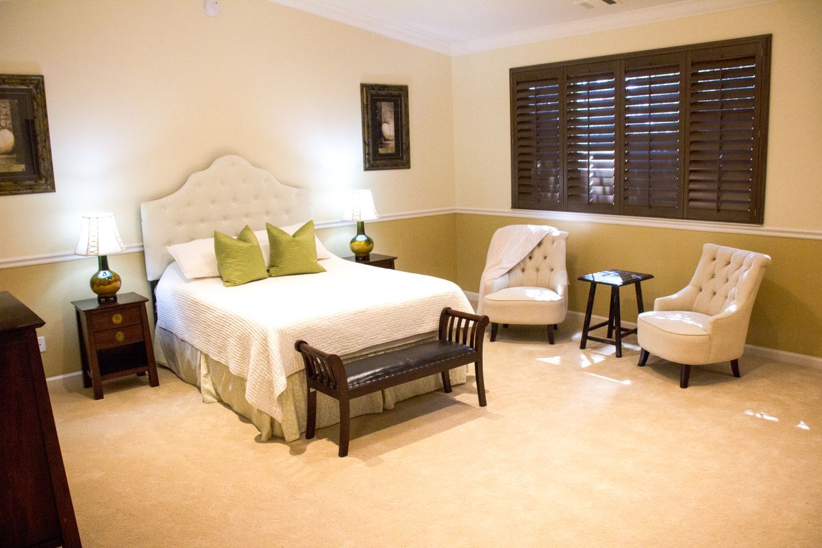 A cozy and well-decorated bedroom with a comfortable bed, stylish furniture, and warm lighting.