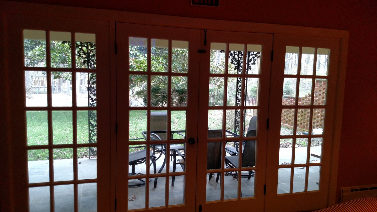 View of a patio with outdoor furniture through French doors.