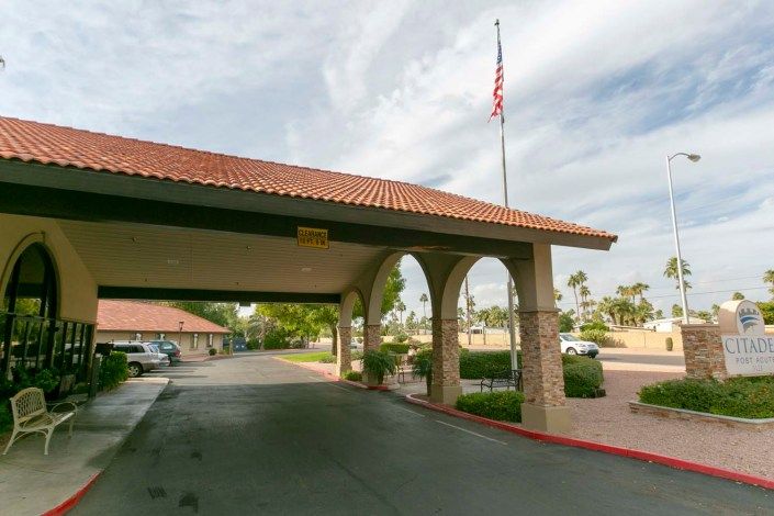 Entrance to a building with arches and an American flag on a flagpole.