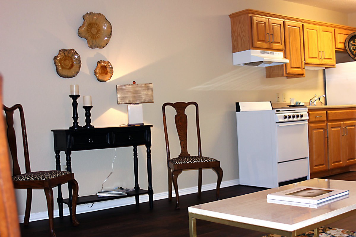 A cozy kitchen with elegant wooden furniture and decorative wall accents.