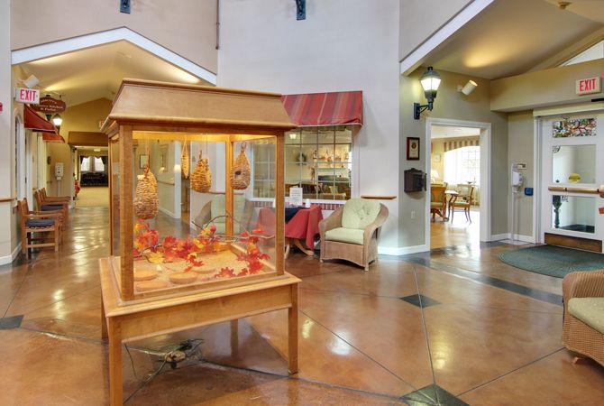 A spacious lobby area featuring a wooden art display case and comfortable seating.