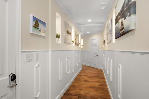 A beautifully designed hallway featuring artistic wall decor and warm wooden flooring.