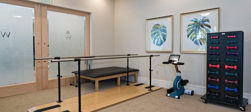 A physical therapy room equipped with parallel bars and exercise equipment.