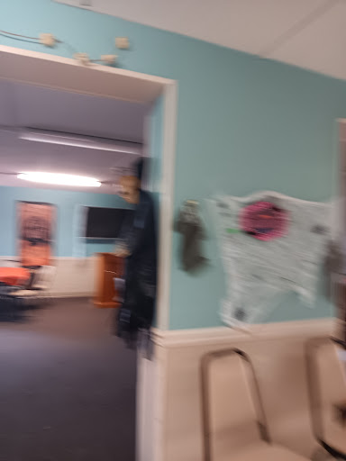 A glimpse into an office space decorated with spooky elements, featuring blue walls and chairs.
