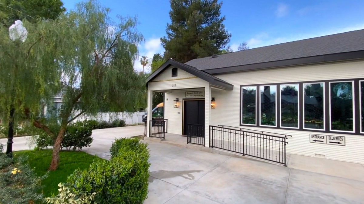 A modern single-story house with a manicured landscape and driveway.
