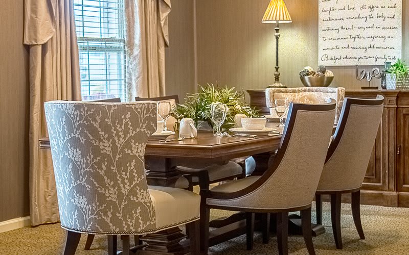 A cozy dining room setup with a wooden table, elegant chairs, and decorative elements.