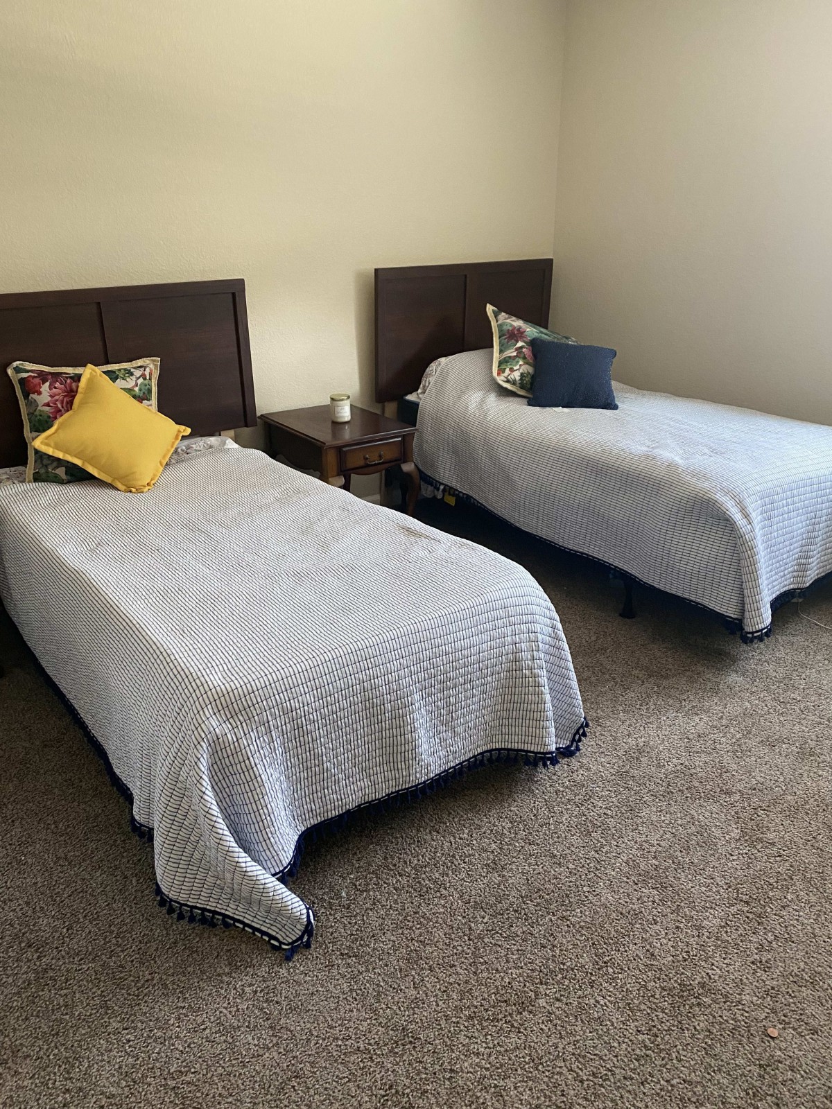A cozy bedroom with two twin beds adorned with pillows.