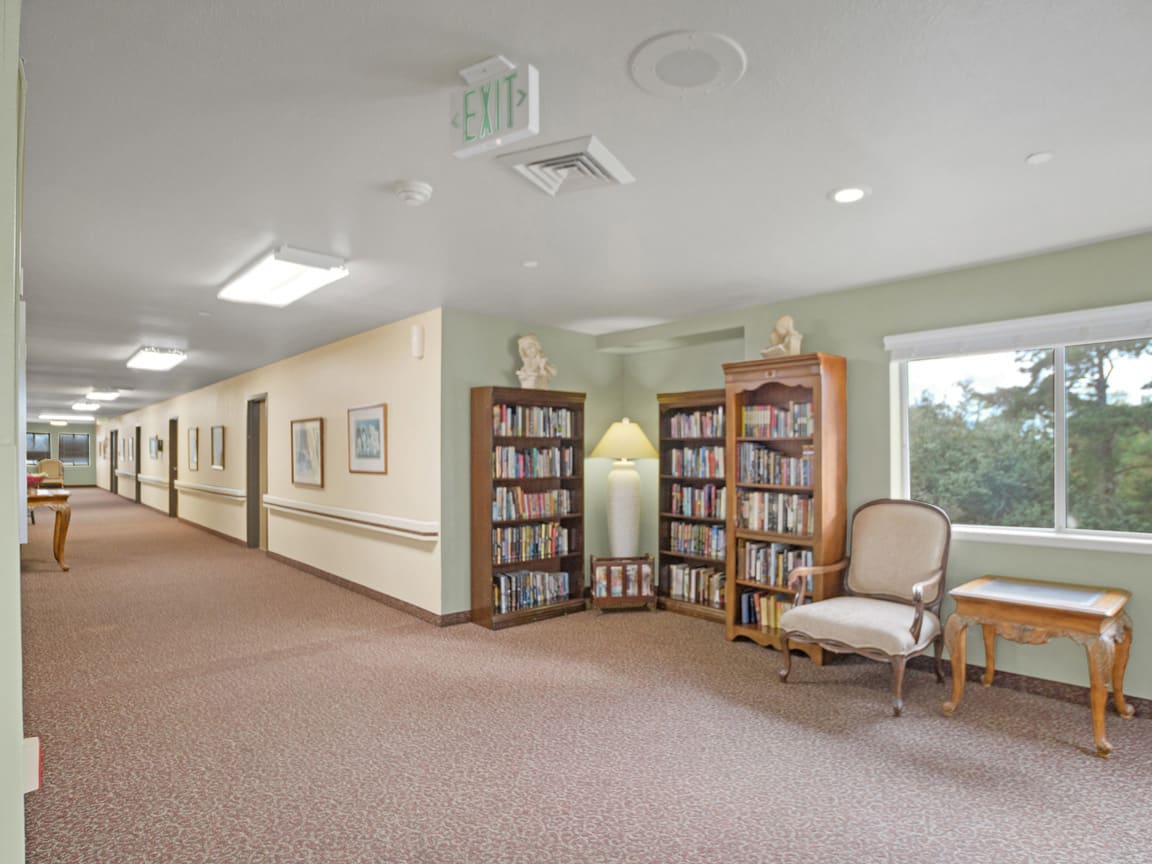 A quiet hallway with bookshelves and a seating area.