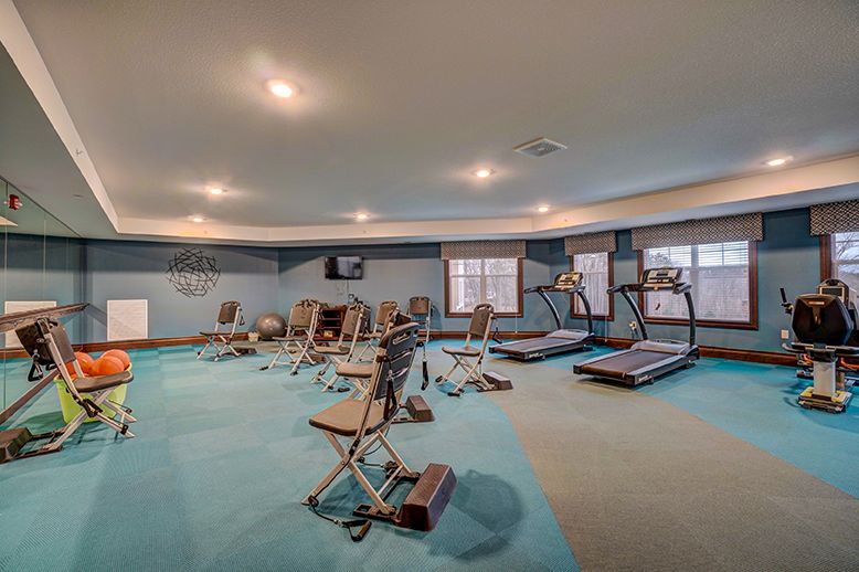 A spacious gym with various exercise equipment including treadmills and strength machines.