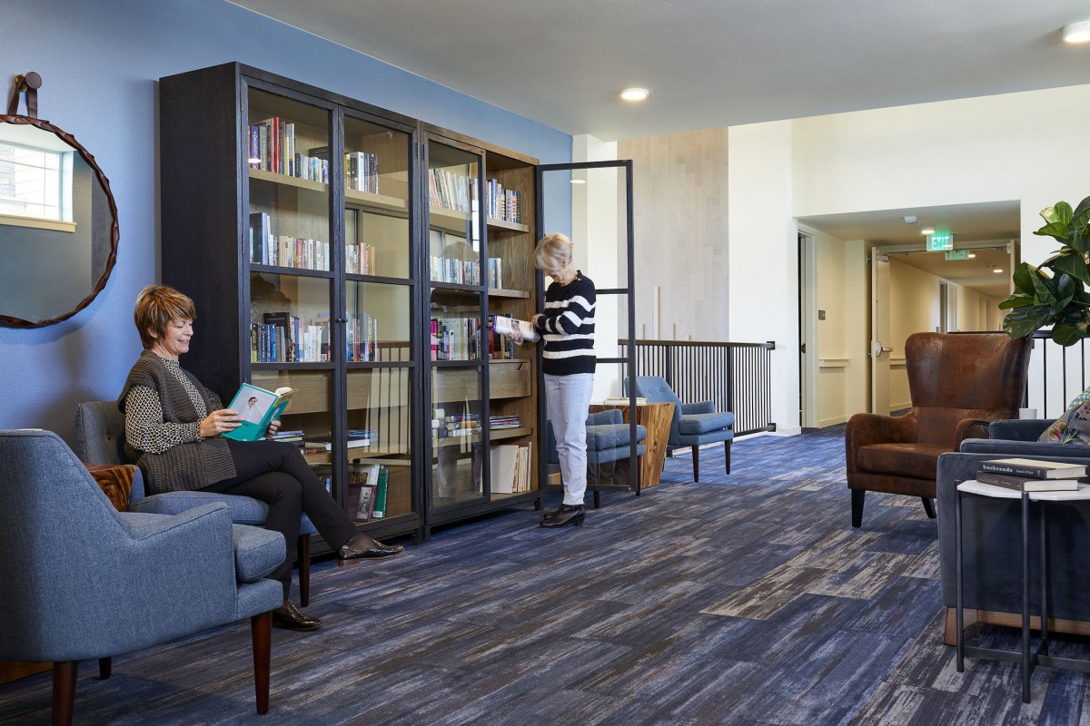 People reading and browsing books in a cozy library setting.