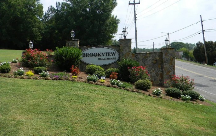 Entrance sign to a neighborhood with well-maintained landscaping and flowers.