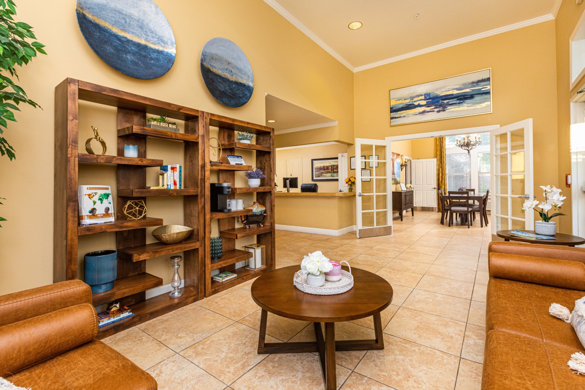 A modern lobby area featuring wooden bookshelves, contemporary artwork, and a reception desk.