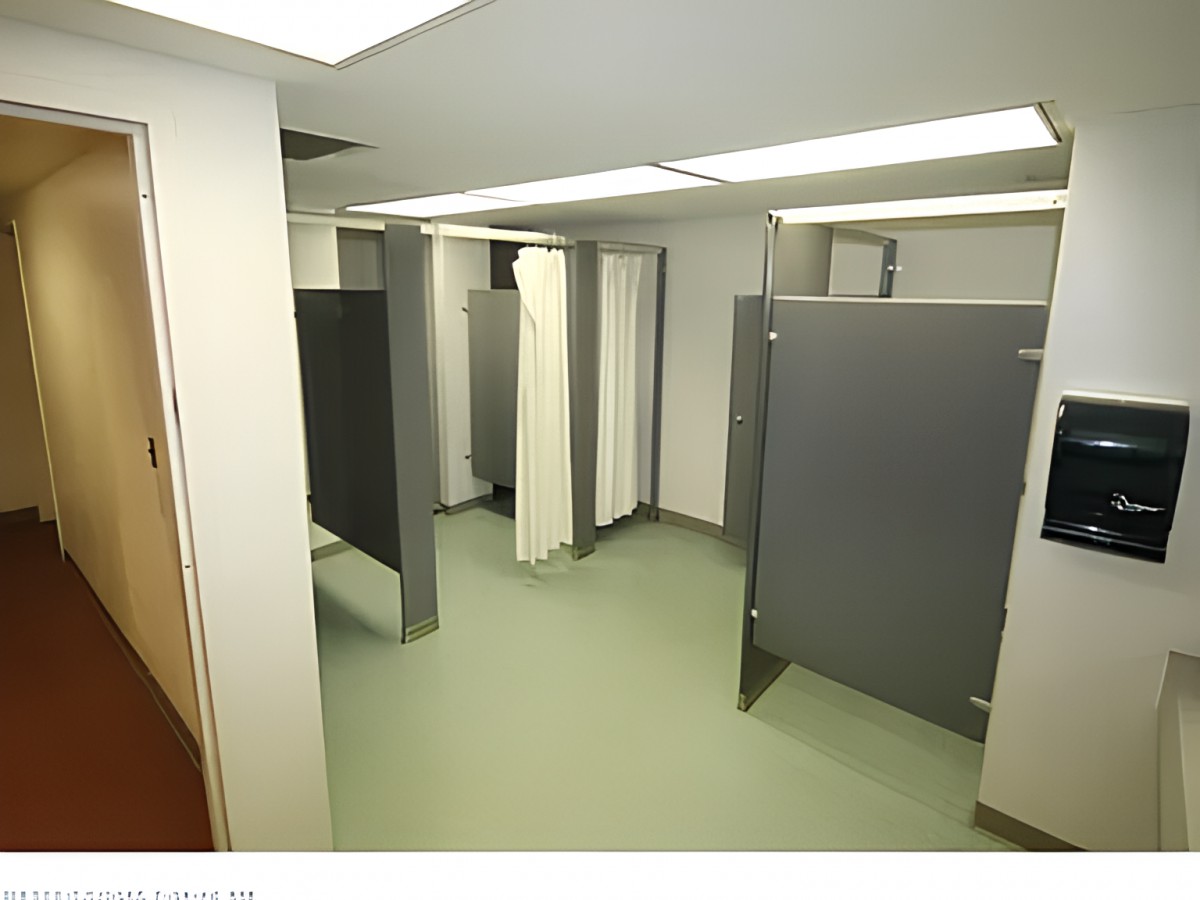 A public restroom featuring multiple stalls with dividers.