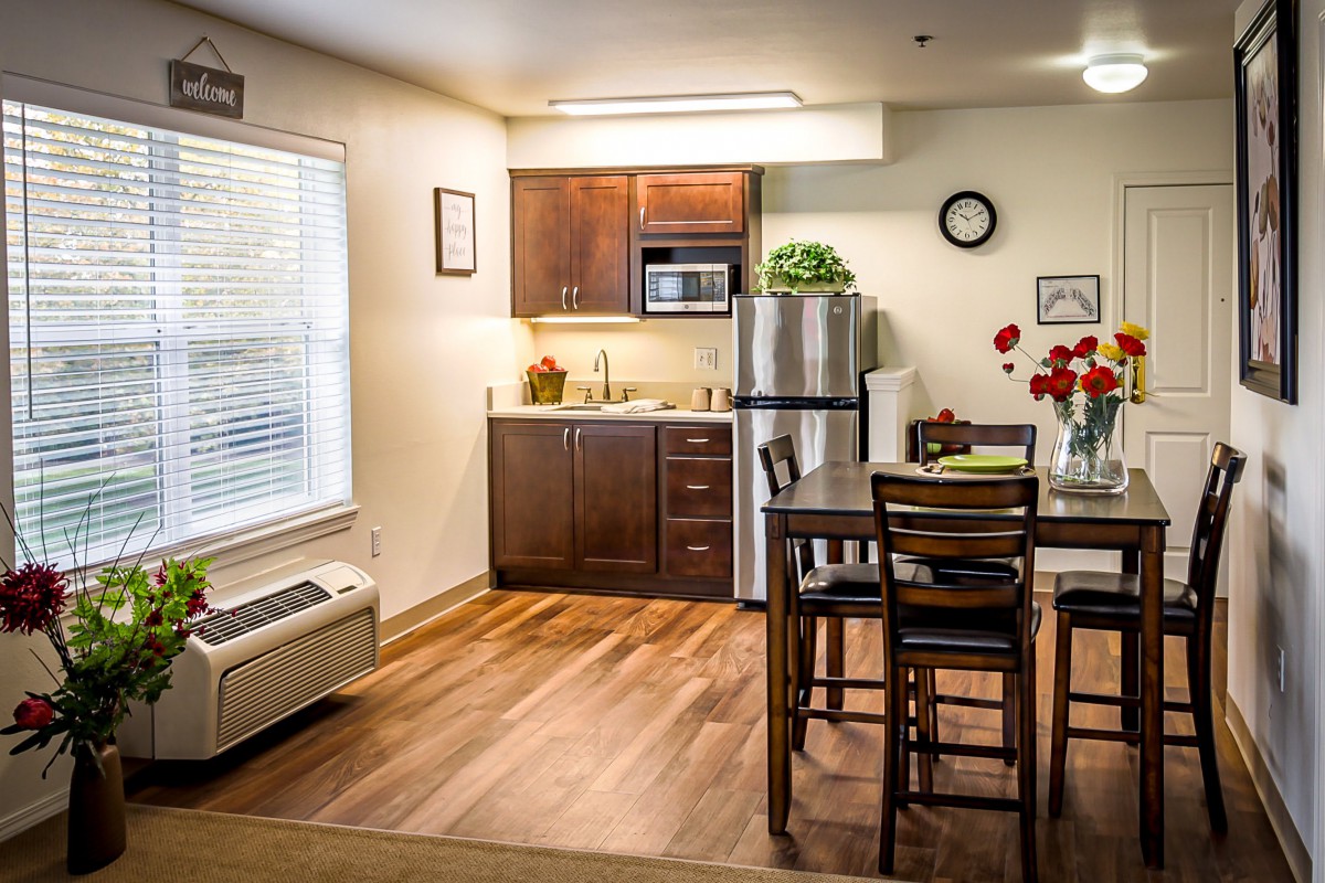 A modern kitchen and dining area with stainless steel appliances and hardwood floors.