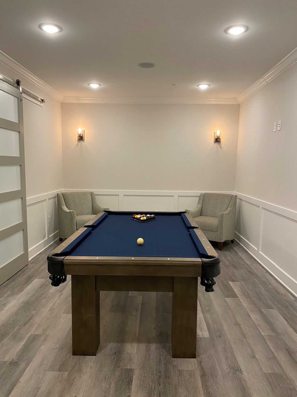 A modern game room featuring a blue billiard table and cozy seating.