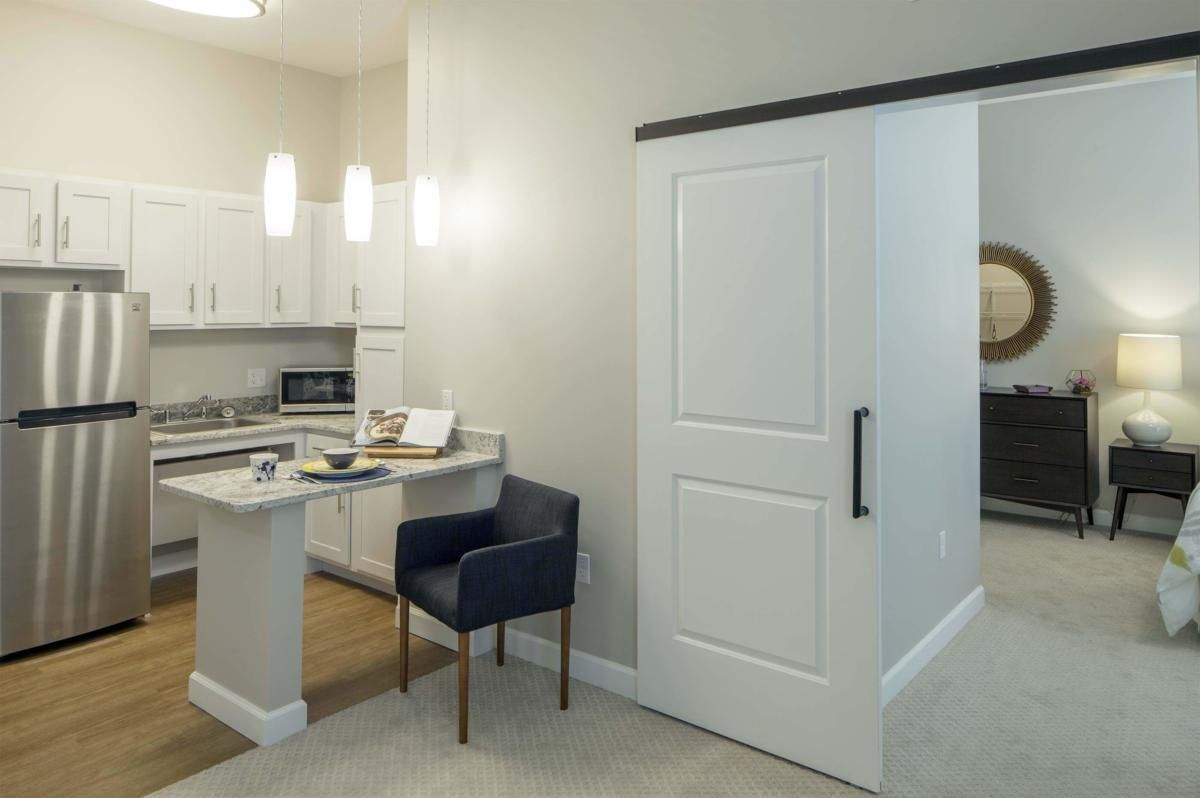 Modern kitchen interior with a sliding door and cozy seating area.