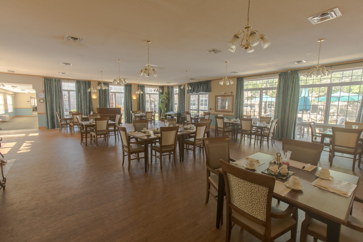 Spacious restaurant dining area with elegant chandeliers and natural lighting.