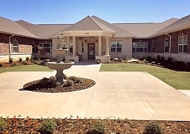 A single-story house with a neatly landscaped garden and driveway.
