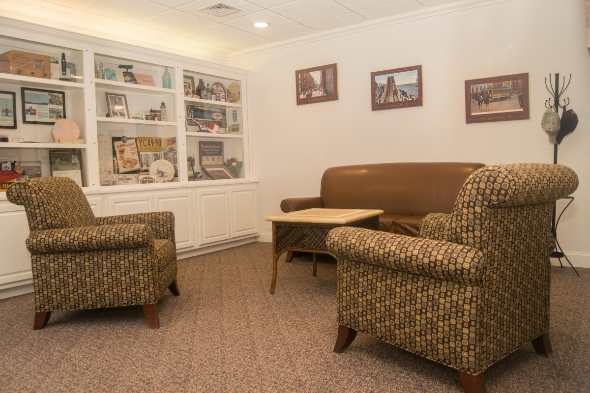 A cozy waiting room with comfortable seating and decorative shelves.
