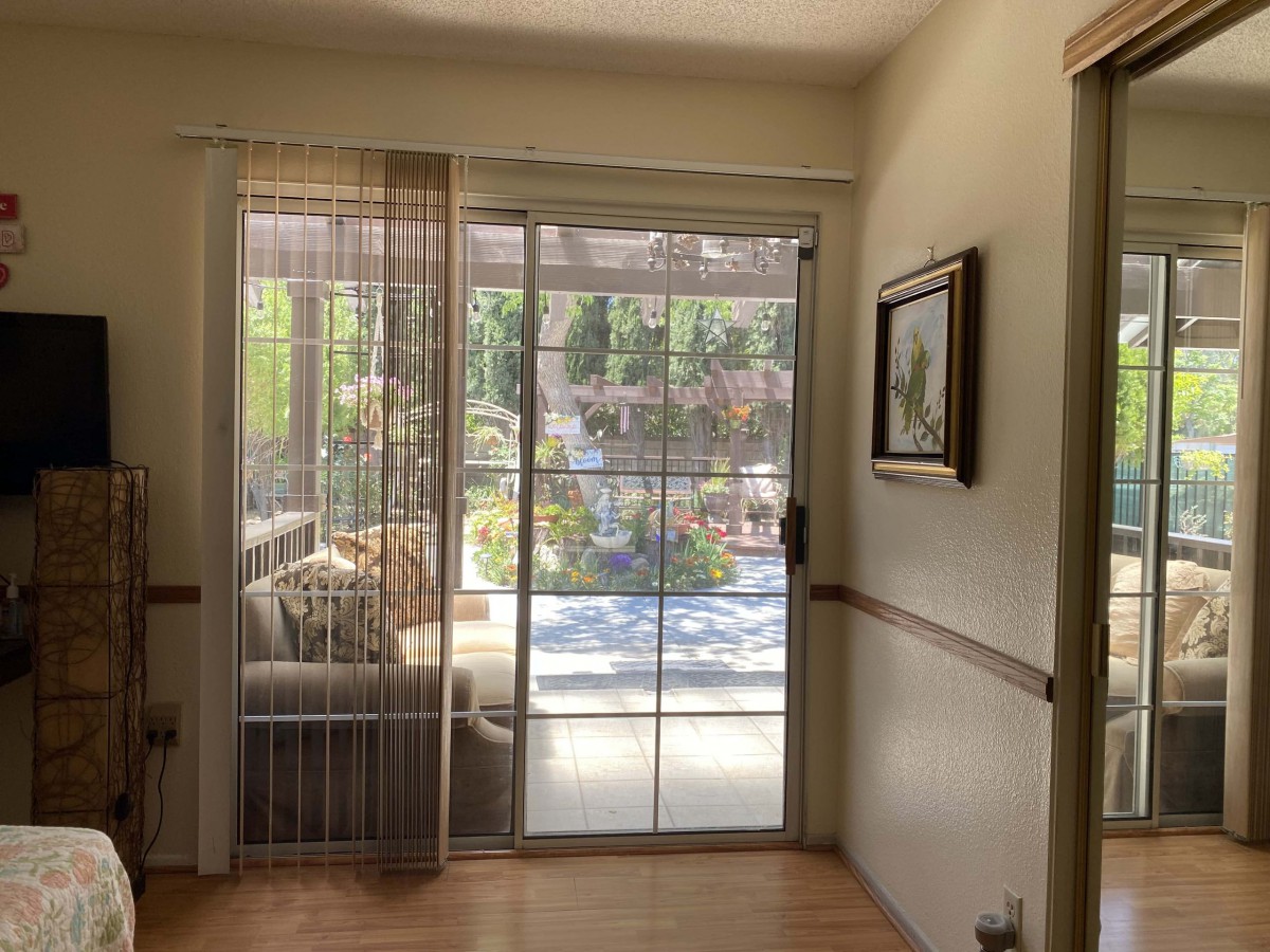 A cozy living space with a sliding glass door leading to a garden.