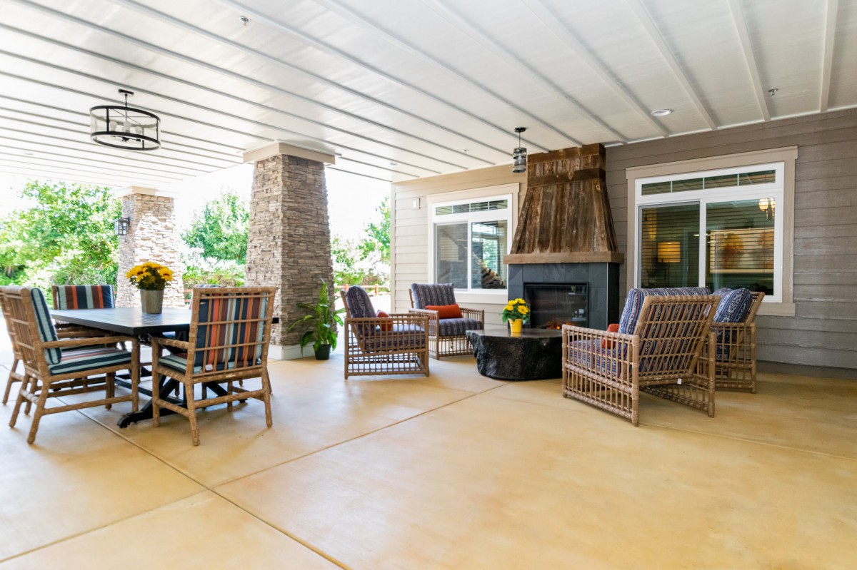 A cozy outdoor patio with comfortable seating and a fireplace, perfect for relaxation.